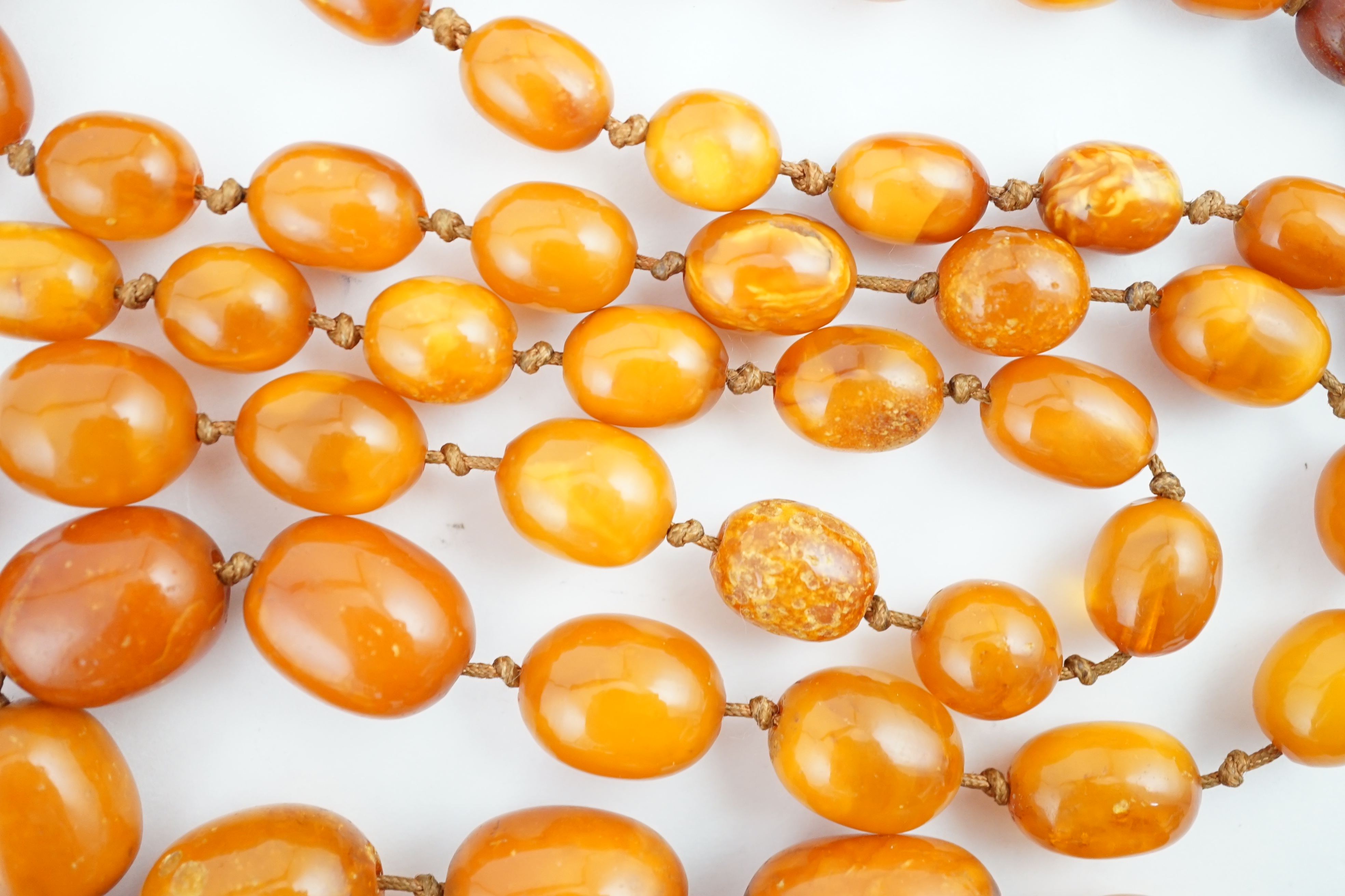 A long single strand graduated amber bead necklace